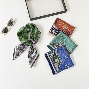 Flat lay of colorful paisley pattern silk square scarves with sunglasses decoration
