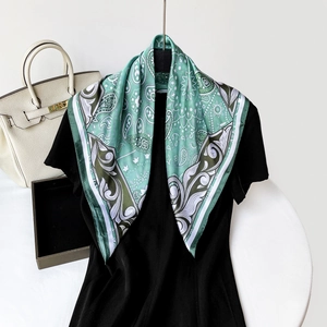 Close-up of silk-like green paisley square scarf draped on a display model