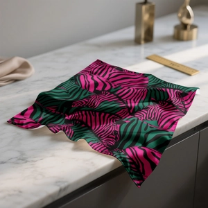 Pink and green zebra print satin scarf with smooth silk texture on white marble surface