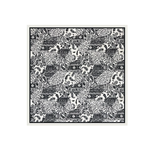 Macro view showing the paisley pattern and black geometric border of the square satin scarf