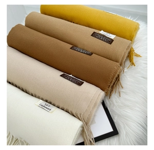 Close-up detail of soft virgin wool scarves with fringe edges in elegant neutral tones