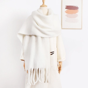 Detail of soft white mohair scarf with tassels on mannequin for winter styling