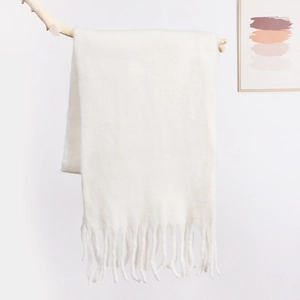 Close-up of cream white mohair scarf with fringe detail on a minimal wooden hanger
