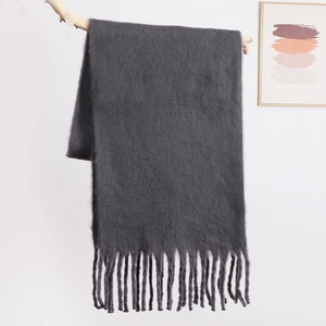 Detail view of the plush charcoal grey scarf texture with elegant long fringe hanging