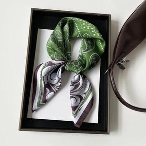Detail of silk-like paisley square scarf with green and purple color block knot