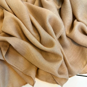 Detailed close-up of premium camel chiffon scarf with fine plain weave texture and drape