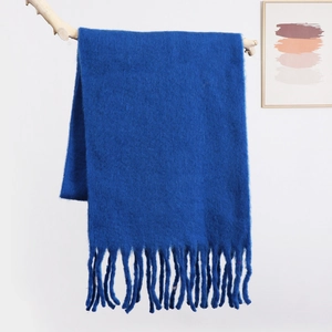 Macro shot of fluffy royal blue mohair scarf fabric texture and thick tassel detail