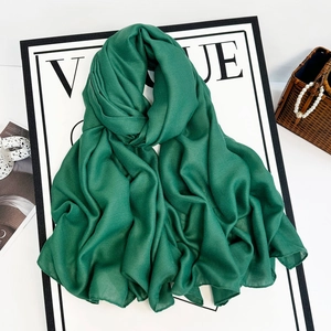 Detail view of emerald green linen-feel hijab scarf with pleated texture and soft fabric