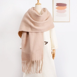 Close-up detail of soft pink knit scarf with long fringe trim on a mannequin