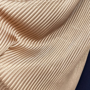 Elegant pleated satin silk scarf in champagne gold with fine plissé texture and metallic sheen