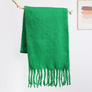 Macro shot of fluffy grass green mohair scarf showing soft brushed texture and long fringes
