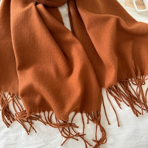 Macro detail of caramel cashmere scarf fabric texture with soft fringe tassels