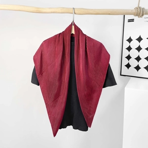 Detailed close-up of dark burgundy pleated satin shawl scarf on a wooden hanger