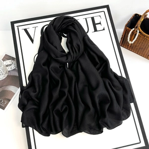 Close-up of lightweight black cotton-linen scarf with fringed edges and soft texture