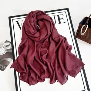 Close-up of burgundy long scarf with subtle texture and neat overlock edge detail