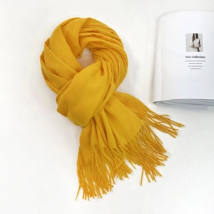 Detail of bright yellow soft pashmina scarf with elegant fringe edges and textured weave