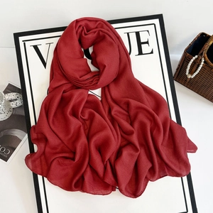 Detail of burgundy long hijab scarf with soft crinkle texture on vogue display board