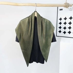 Detailed view of dark green pleated silk scarf on wood rod with black knit shirt