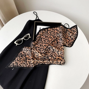 Detail of leopard print pleated scarf and fashion accessories on white table