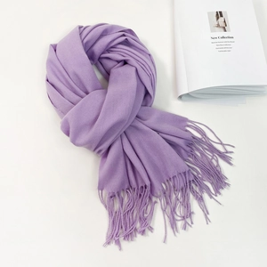 Detail of soft purple cashmere-feel scarf featuring fine long fringe tassels and elegant texture