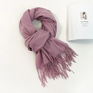 Detailed close-up of soft lavender cashmere-feel shawl with fine tassel edge on white background