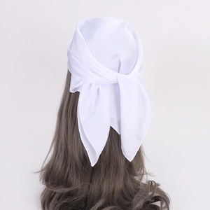 Detail of white satin silk scarf tied as a headband on long brown hair with soft sheen