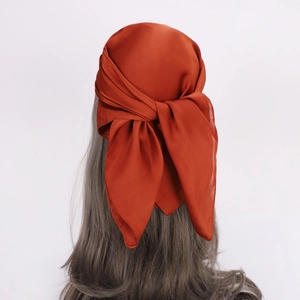 Rust red satin silk square scarf tied as a headscarf with elegant glossy finish