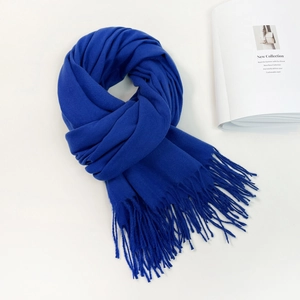 Detailed close-up of a royal blue faux cashmere scarf with fringe on a white background