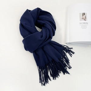 Detailed close-up of dark blue pashmina scarf with elegant long fringes on white background