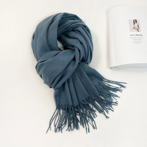 Detailed close-up of blue cashmere scarf with elegant fringe trim and soft fabric texture
