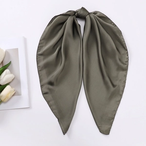 Detail view of dark green satin scarf showing silky texture with a top knot and tulips
