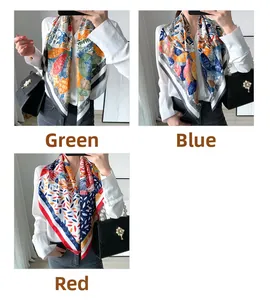 Détail d'un foulard carré en soie aux motifs floraux et géométriques vert, bleu et rouge