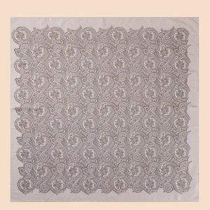 Detailed close-up of beige twill silk scarf with intricate grey paisley floral patterns