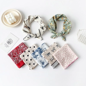 Detailed flat lay of printed cotton-linen square scarves with vintage and floral patterns