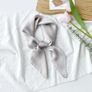 Nahaufnahme des verknoteten, hellgrauen Satin-Vierecktuchs mit elegantem Glanz