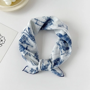 Detail of blue Toile de Jouy print on a white cotton silk square scarf with knotted texture