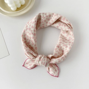 Close-up of small floral cotton square scarf with pink edges and delicate knot detail