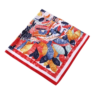 Gros plan détaillé d'un foulard en soie carré aux motifs botaniques abstraits et bordure rouge