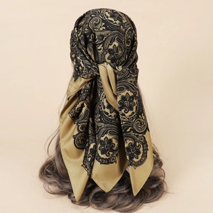 Detailed view of bronze paisley satin scarf worn as a headpiece on long hair