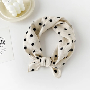 Elegant cotton square scarf with black polka dots on cream fabric in a tied display