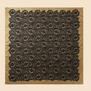 Close-up of golden paisley satin square scarf showing intricate floral silk texture