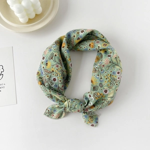 Detail of light green floral cotton neck scarf showing fine rolled hem and knot design