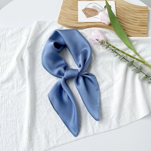 Eleganter nebelblauer Satin-Viereckschal auf Holztablett mit Tulpen dekoriert