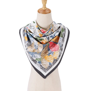 Détail d'un foulard en soie à imprimé floral, couleurs vives et bordure rayée sur mannequin