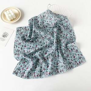 Close-up of small floral print on soft cotton scarf with delicate rolled hem finish
