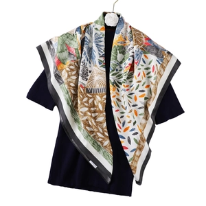 Détail d'un foulard en soie à fleurs multicolores avec bordure noire sur un haut noir