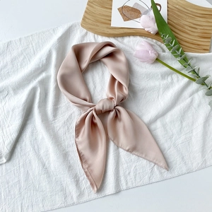 Details eines eleganten champagnerrosa Satin-Halstuchs mit Glanz und dekorativem Knoten