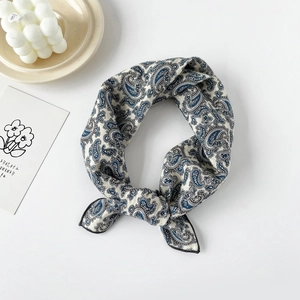Detail of blue Paisley pattern on beige cotton silk square scarf with fine black hem edge