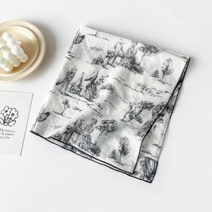 Detail of floral Toile de Jouy print on a white cotton scarf with black stitched edges