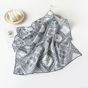 Detailed view of white paisley cotton square scarf with navy blue floral patterns